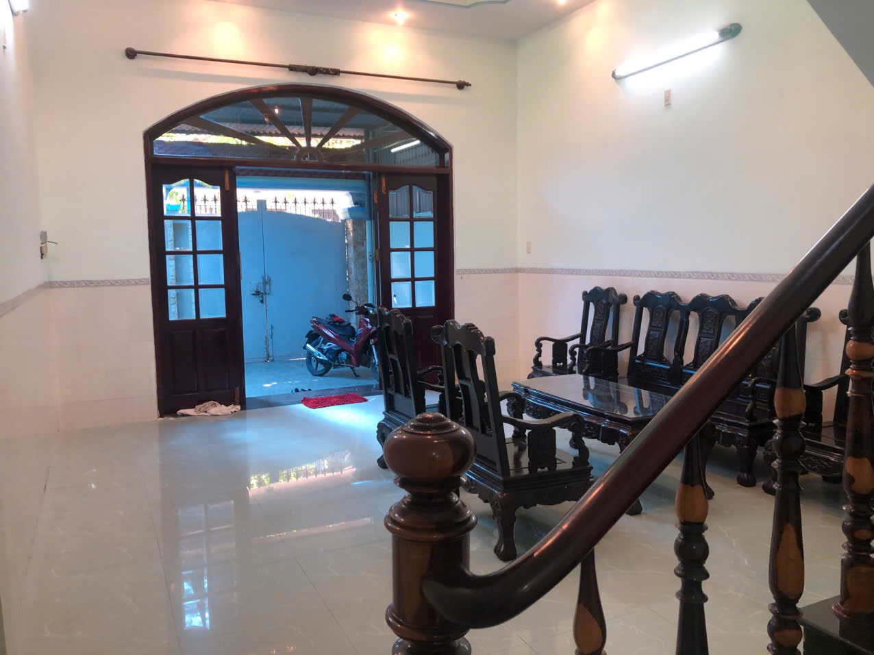 Phòng khách nhà B027 Vĩnh Hải với bộ bàn ghế gỗ và cầu thang