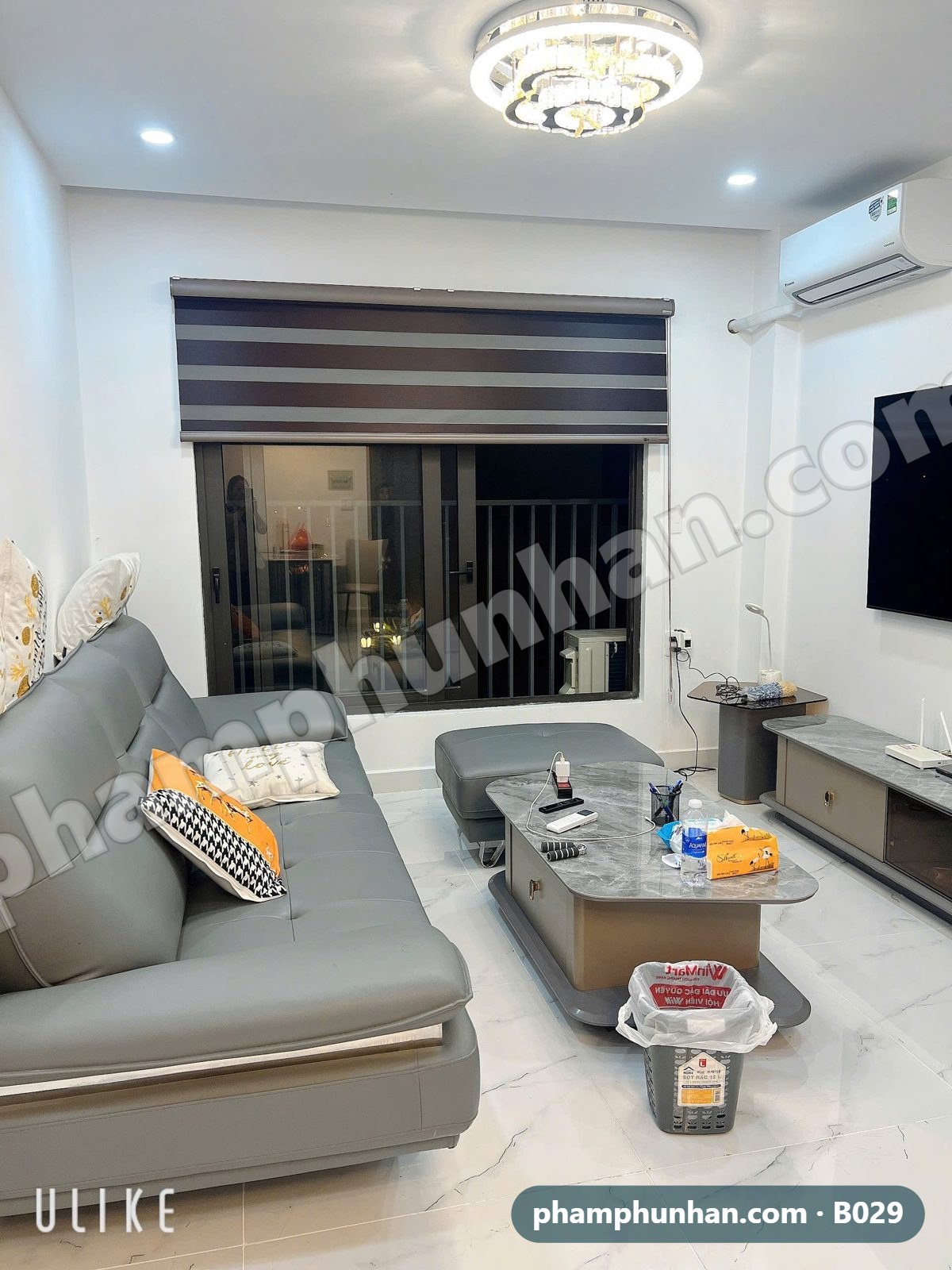 Phòng khách sofa da xám, cửa kính ra ban công