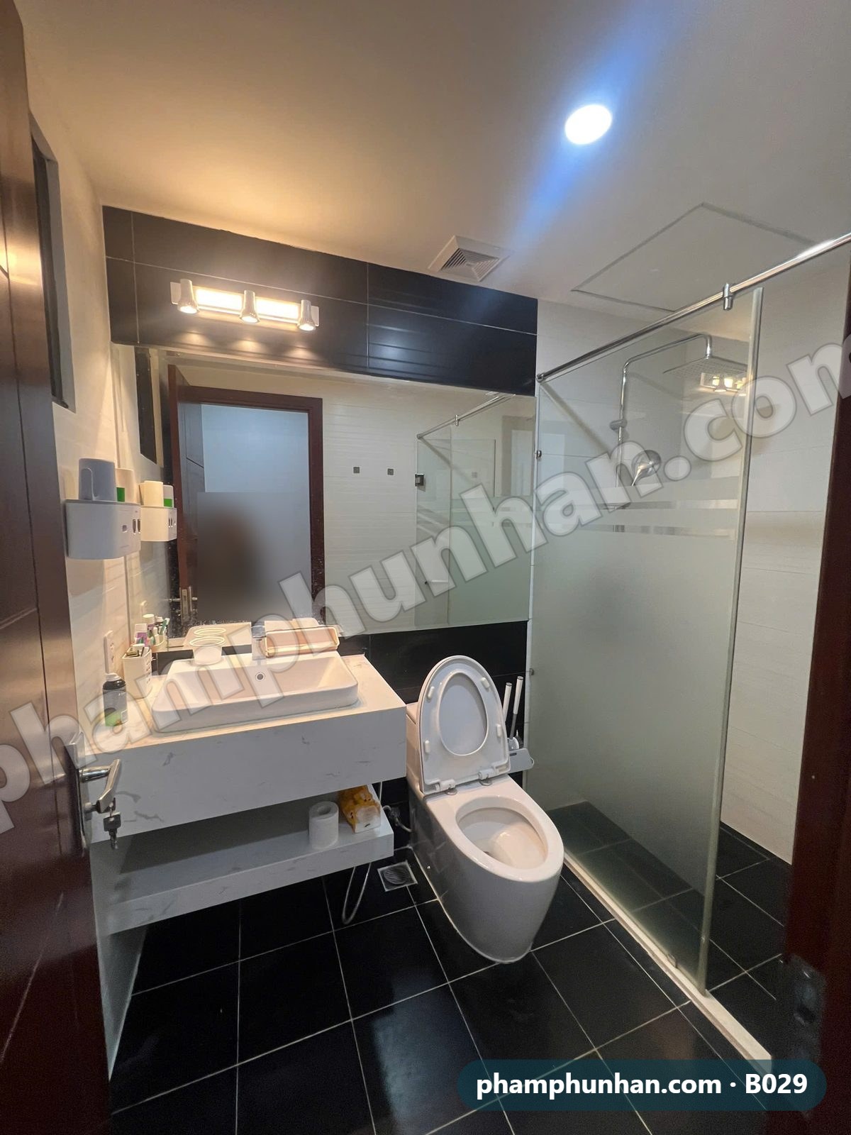 Phòng tắm vách kính, lavabo đá, sàn gạch đen