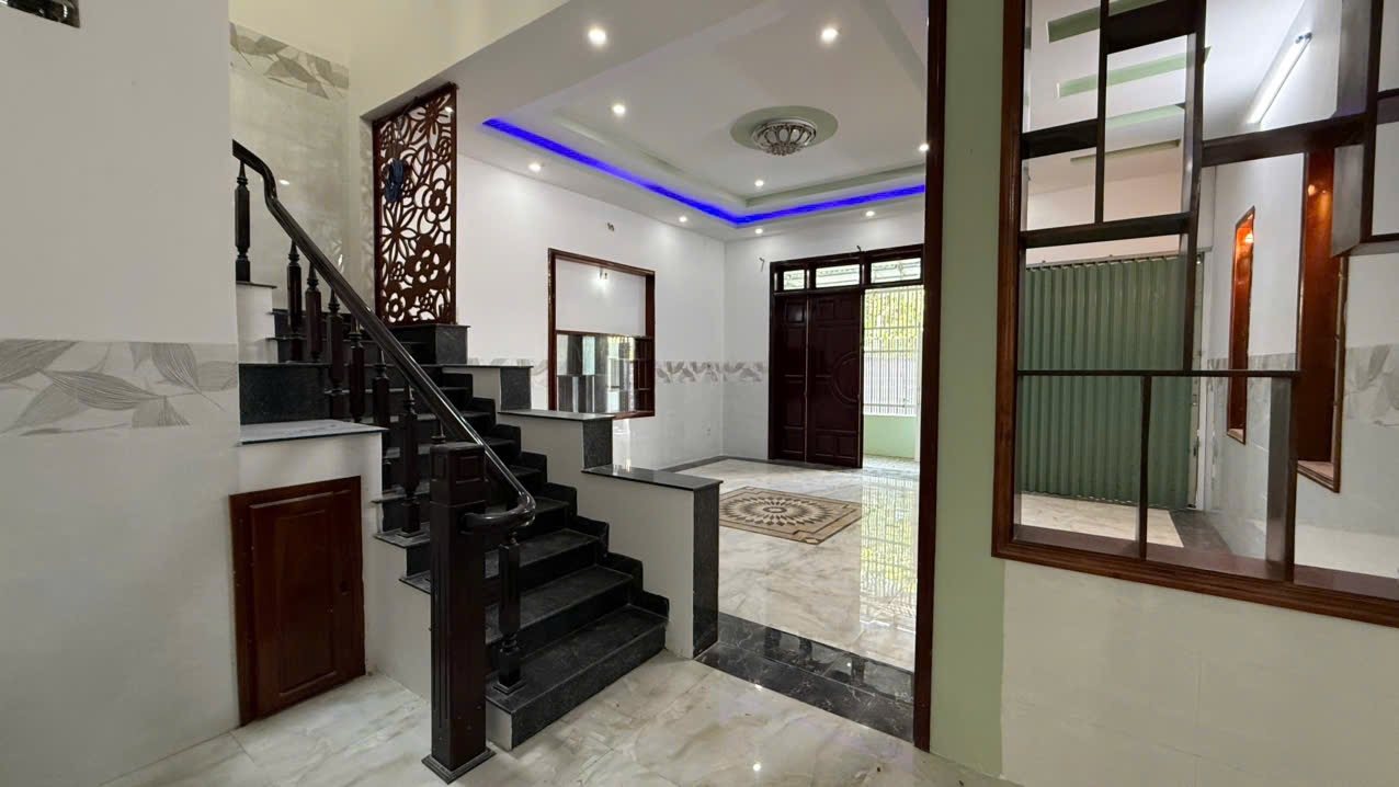 B036 – Từ chân cầu thang nhìn ra phòng khách và cửa chính gỗ 4 cánh